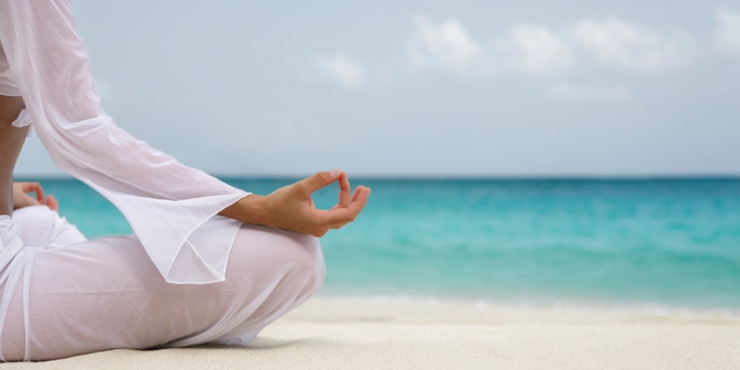 woman meditating on the beach